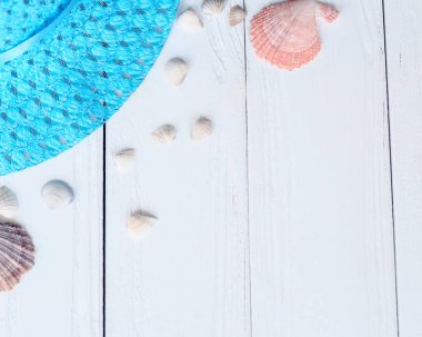 Hasır şapka ve kabukları üzerinde metin için yer ile ahşap background.photo