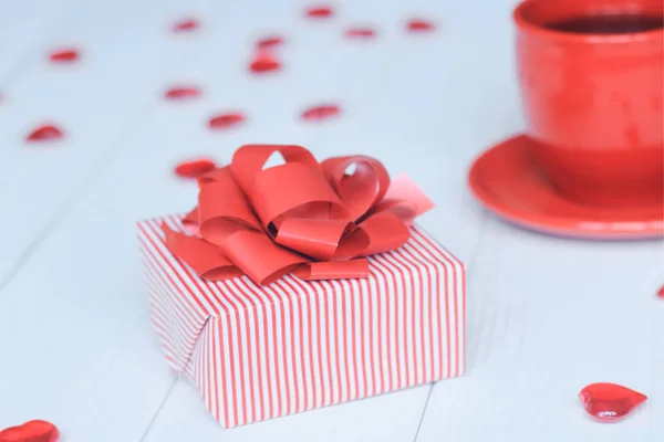 Nahaufnahme Hintergrundbild der roten Tasse und Geschenkbox auf hellem Hintergrund. — Stockfoto