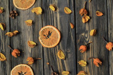 portakal dilimleri ve ahşap arka plan üzerinde kurutulmuş çiçek yaprakları