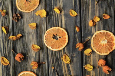 portakal dilimleri ve ahşap arka plan üzerinde kurutulmuş çiçek yaprakları