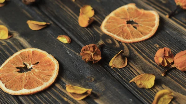In Scheiben geschnittene Orangen- und Hibiskusblüten auf Holzgrund — Stockfoto