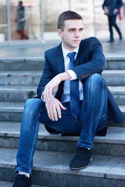 Joven empresario sentado en los escalones de la oficina — Foto de Stock