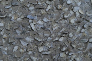 Malzemelerinin duvarları beton ve taşlarla kaplı. Prefabrik ev. Gri bina malzemelerinden. Küçük taşlar. Sıkıcı taş..