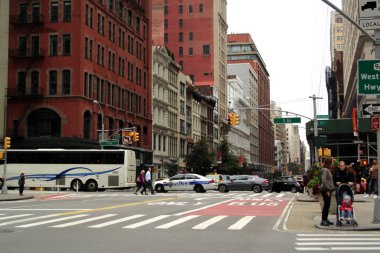 Traffic of cars and pedestrians at a crossroads in downtown New York, intersection of 5th Avenue and Broadway.