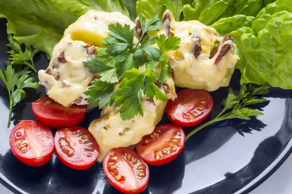 Potatoes stuffed with bacon and small tomatoes close — Stock Photo, Image