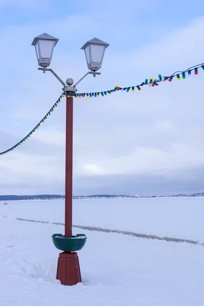 Pouliční lampa na nábřeží říčky zamrzlé jezero — Stock fotografie