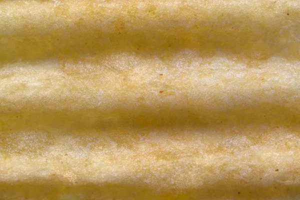 Макротекстура гофрированных картофельных чипсов — стоковое фото