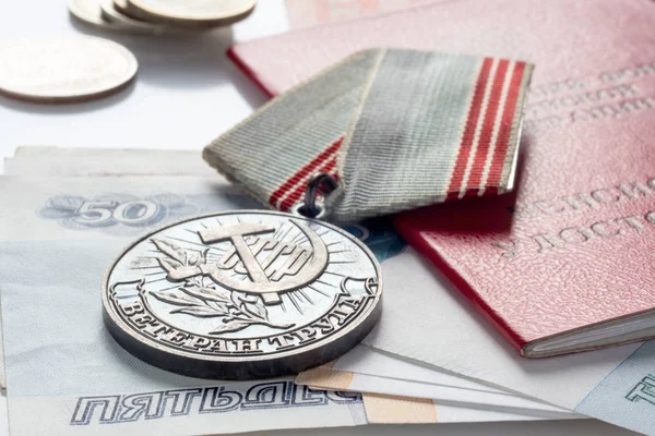 Медаль ветерана труда, пенсионное удостоверение и деньги — стоковое фото