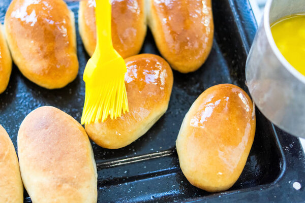 Grease freshly baked pies with butter