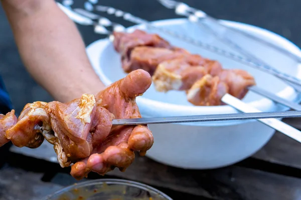 Les mains mettent la viande de porc sur une brochette — Photo
