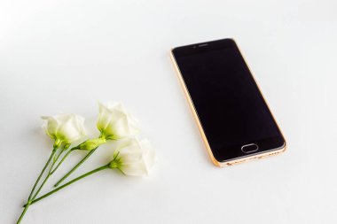 Hassas beyaz çiçekler ve modern güçlü smartphone