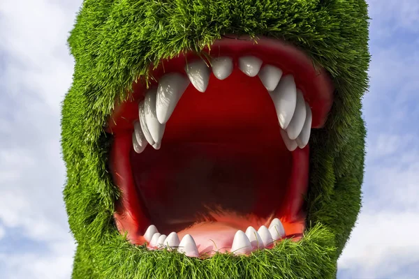 Dinosaur head with open mouth covered with artificial green grass