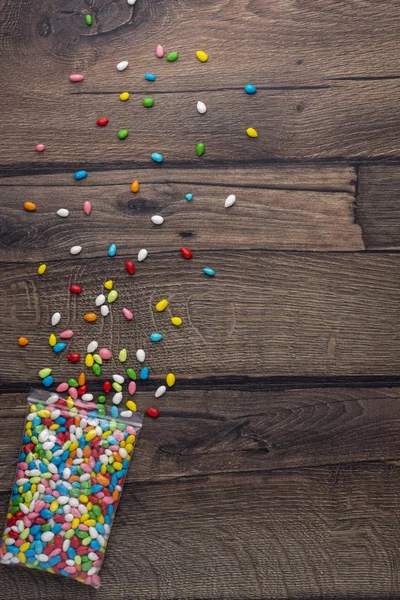 Caramelle Smalto Multicolore Fuoriuscite Dal Pacchetto Fondo Legno — Foto Stock