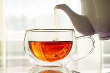 Çay fincanındaki çaydanlıktan gelen güzel kokulu çay.