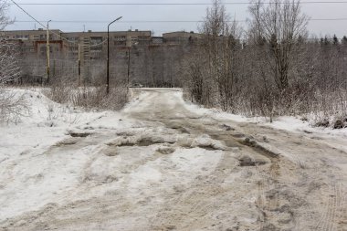 Rus şehrinde kışın derin çukurlar, su, buz ve kar olan kötü bir yol.