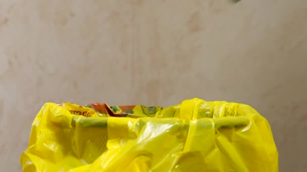 人类的手把用过的面罩和手套送到黄色的垃圾袋里 — 图库视频影像