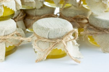 Bir kavanoz doğal kokulu kehribar balı, pürüzlü jüf beziyle kaplı.