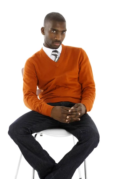 Hombre de negocios africano sentado en serio en un estudio con un — Foto de Stock