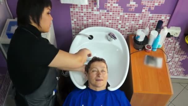 Cosmetologist washes the womans head — Stock Video