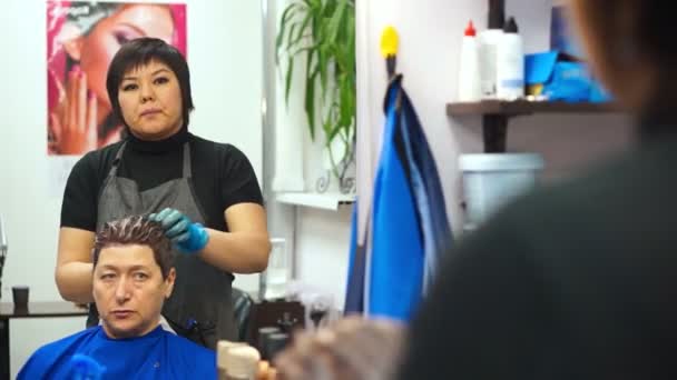 Der Friseur arbeitet und lacht — Stockvideo