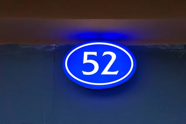 Letrero con el número de la casa 52 brillan en la noche en la calle — Foto de Stock