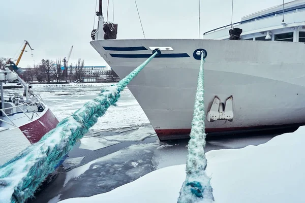 The ship is moored in the port in winter under snow with thick ropes to the bollard — Stock Photo, Image
