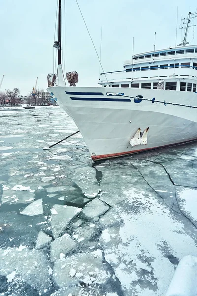 A white blue passenger ship anchored in a frozen river covered with ice and snow — Stock Photo, Image