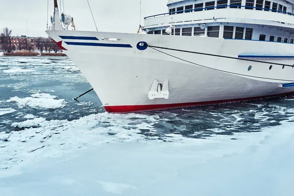 A white blue passenger ship anchored in a frozen river covered with ice and snow — Stock Photo, Image