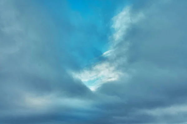 Grå moln på en blå vinterhimmel med en solbelyst — Stockfoto