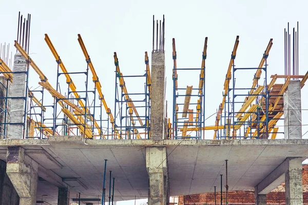 Construção de um novo edifício no inverno na cidade de tijolo e concreto com o uso de um guindaste — Fotografia de Stock
