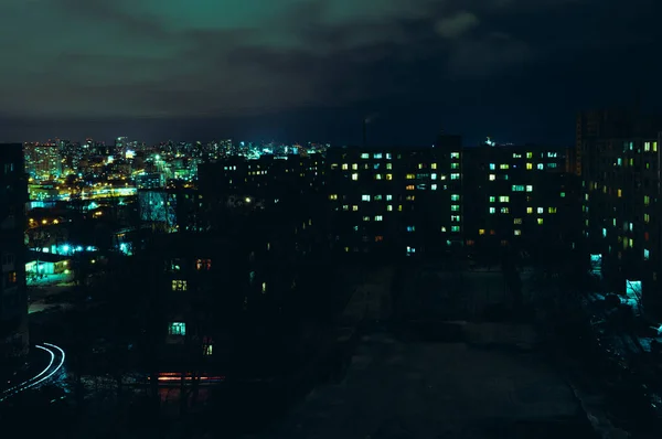 Blick auf die nächtlich helle Stadt in Lampen und Lichtern mit kleinen Wolken am Himmel — Stockfoto