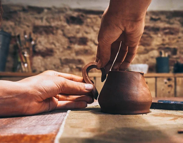 People with dirty hands creates a clay pot milk jug in the pottery workshop — Stock Photo, Image