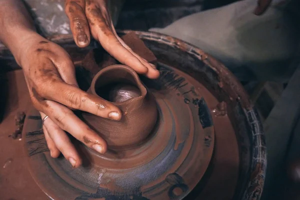 Люди с грязными руками создают глиняный кувшин молока в керамической мастерской — стоковое фото