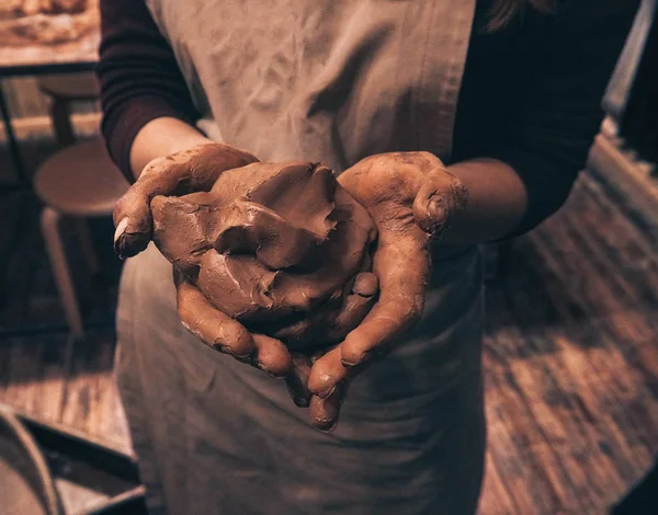 Люди с грязными руками создают глиняный кувшин молока в керамической мастерской — стоковое фото