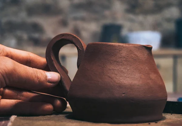 Le persone con le mani sporche creano una brocca di latte in terracotta nel laboratorio di ceramica — Foto Stock