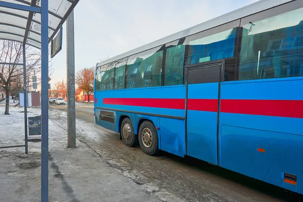 Un autobús azul alto con una pequeña puerta se para en una parada esperando a la gente —  Fotos de Stock