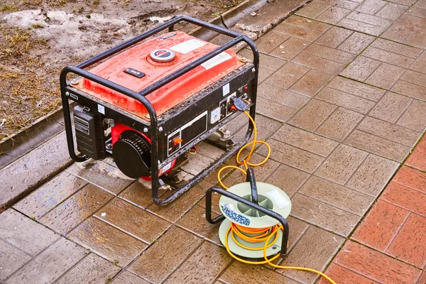 Turuncu bir tel üzerinde sokakta küçük bir kırmızı jeneratör elektrik verir
