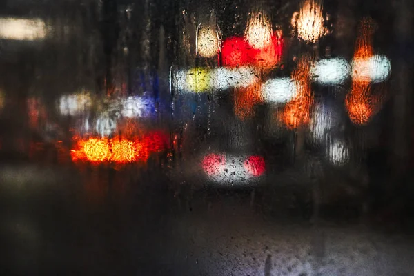 Keresztül a páraként üveg a videobusz az éjszakai város fényeit és autók — Stock Fotó
