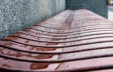 Ahşap Bank dalgalı formu ile sokakta yağmur kapattıktan sonra su birikintileri