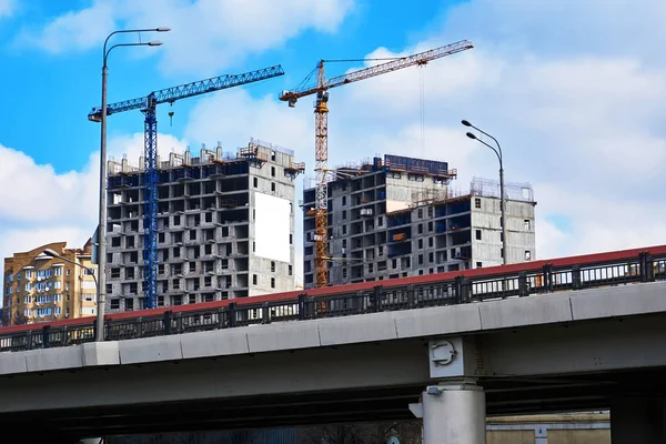 Construção de dois edifícios altos monolíticos perto do cruzamento de tráfego na cidade grande — Fotografia de Stock