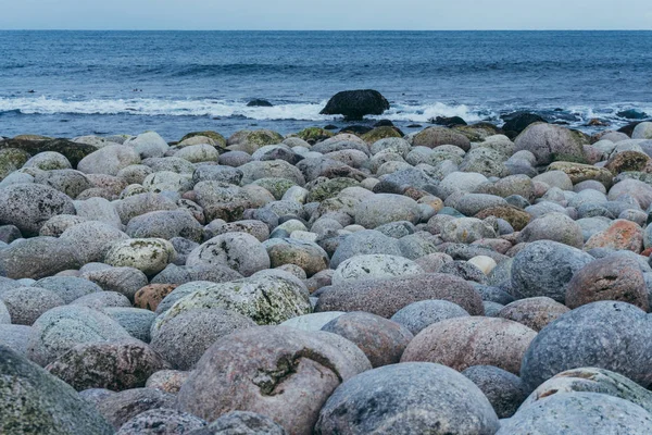 Grandes piedras redondas en la orilla del océano en un tranquilo día de invierno — Foto de Stock