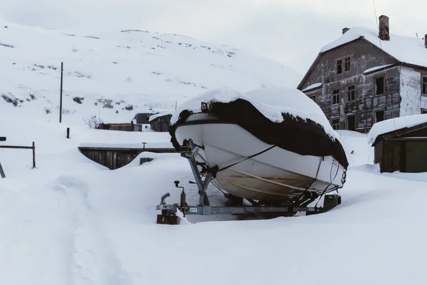 Biały nowoczesnych łodzi w osłonie na samochodowe przyczepy pod śniegiem na stary dom — Zdjęcie stockowe