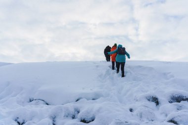 İki genç kız parlak ceket kışın karda boğulma bir Don tundra karlı tepeler üzerinde seyahat