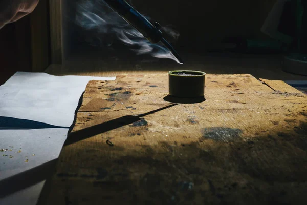 Werken met een ruwijzer soldeerbout thuis onder het middelpunt van de belangstelling en de rook die afkomstig is van vloeibare hars — Stockfoto