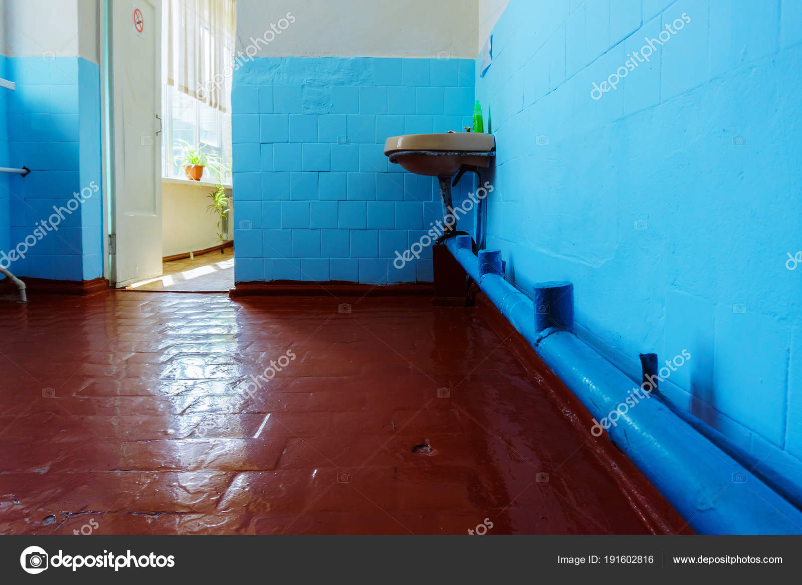 An Old Untreated Bathroom With One Rusty Sink And A Leaking