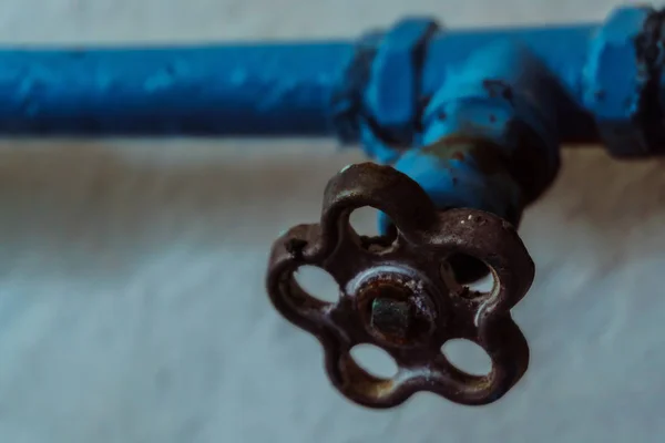 青い色と壁に廃屋に錆がクレーンの古い水道管 — ストック写真
