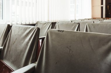 Eski ve rahatsız ahşap kahverengi koltuk üst üste küçük bir okul performansları için küçük bir oda yüklenir