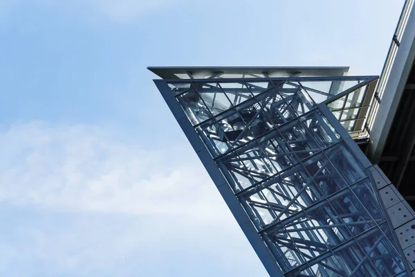 The glass elevator shaft with metal partitions on the street adjoins the bridg