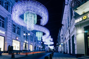 Rostov-on-Don / Rusya - Mayıs 2018: Rostov-on-Don sokaklarında arabalar, yüksek fenerler ve reklam mağazaları 2018 Dünya Kupası beklentisiyle farlar ışığında geceleri