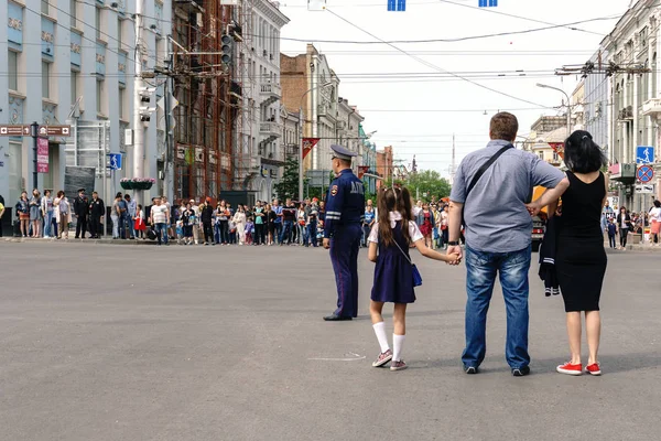 Rostov-on-Don / Rusia - 9 de mayo de 2018: Las personas con banderas y uniforme militar celebran la gran fiesta el 9 de mayo Día de la Victoria a lo largo de las calles centrales de la ciudad caminando por las carreteras cerradas — Foto de Stock